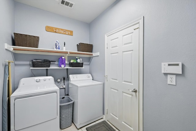 washroom featuring laundry area, tile patterned flooring, washer and dryer, and visible vents