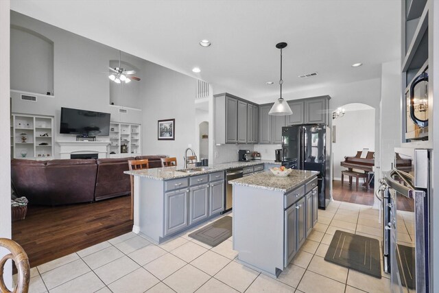 kitchen with appliances with stainless steel finishes, a sink, a peninsula, under cabinet range hood, and a kitchen island