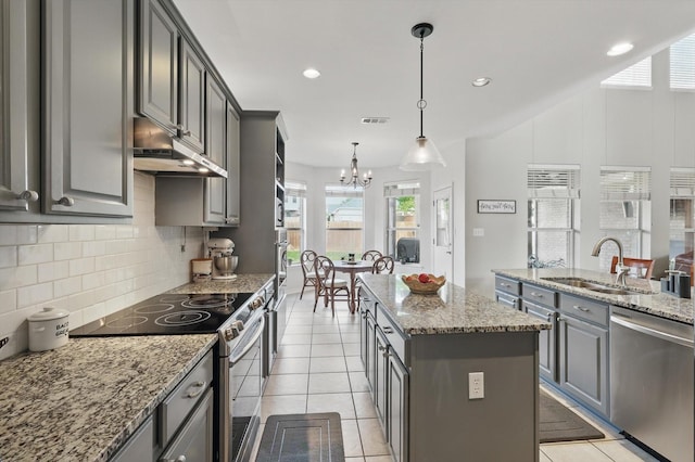 kitchen featuring gray cabinetry, appliances with stainless steel finishes, decorative backsplash, and a sink