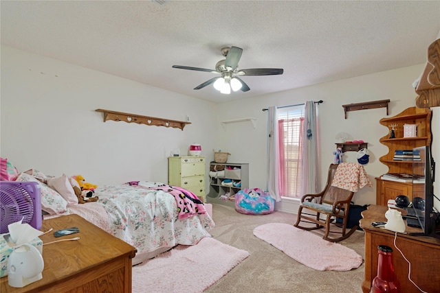 bedroom featuring carpet, a ceiling fan, and a textured ceiling