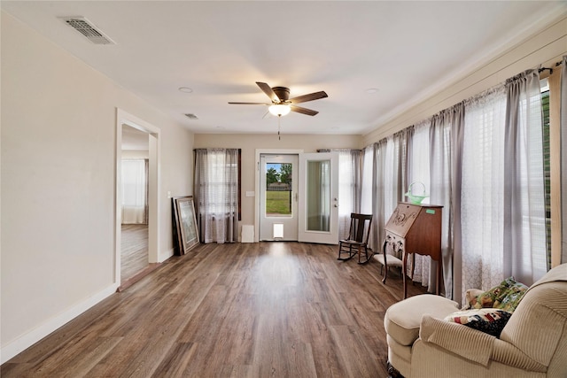sitting room with visible vents, baseboards, wood finished floors, and a healthy amount of sunlight