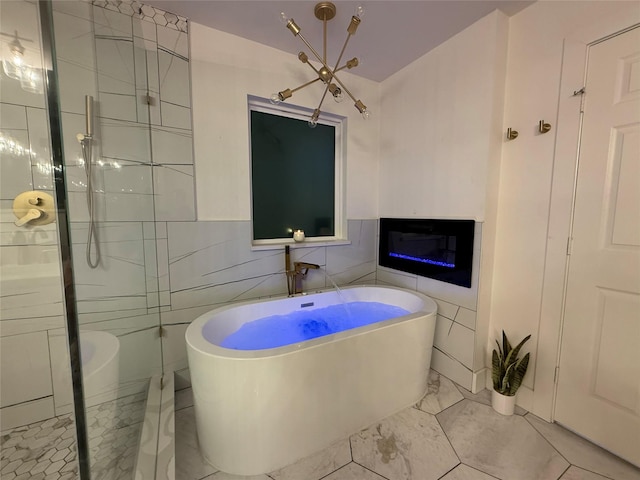 433 Fieldwood Dr, Richardson, TX 75081 - bathroom with a soaking tub, tile walls, marble finish flooring, a stall shower, and a glass covered fireplace