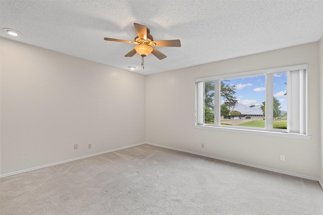 unfurnished room with baseboards, ceiling fan, and light carpet
