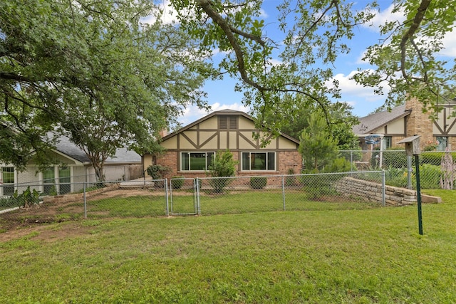 rear view of house featuring a lawn, brick siding, and fence private yard