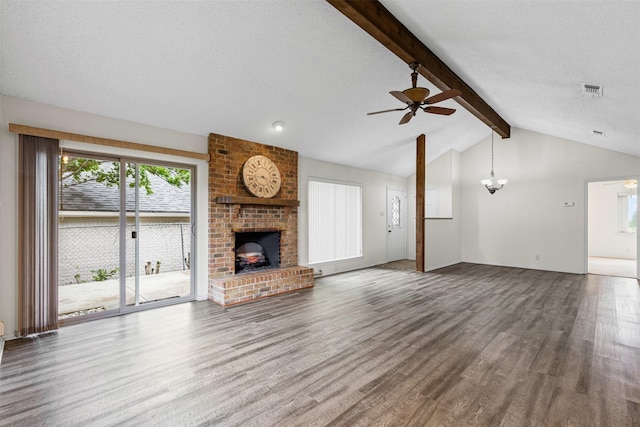 unfurnished living room featuring ceiling fan, a fireplace, vaulted ceiling with beams, wood finished floors, and visible vents