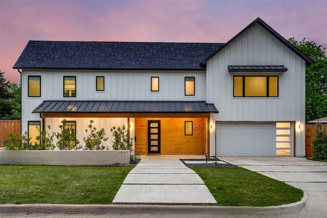 modern farmhouse featuring a garage, metal roof, and a standing seam roof