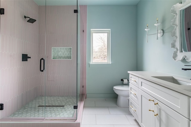bathroom featuring tile patterned floors, a stall shower, vanity, and toilet
