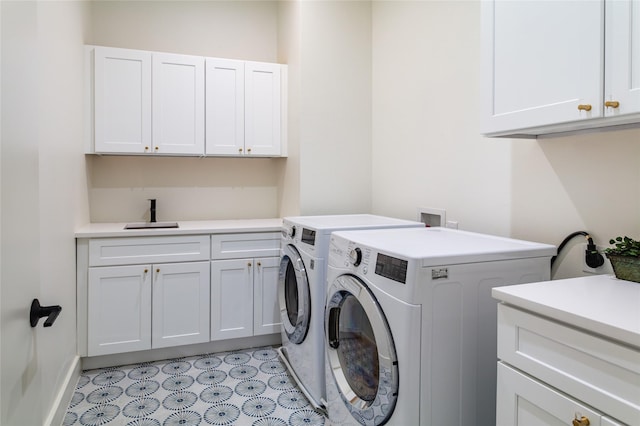clothes washing area featuring a sink, baseboards, independent washer and dryer, and cabinet space