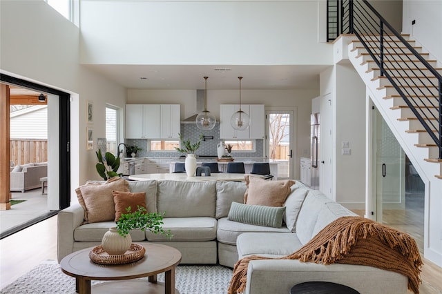 living area with a high ceiling, plenty of natural light, and stairway