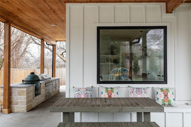 view of patio with an outdoor kitchen, fence, and a grill