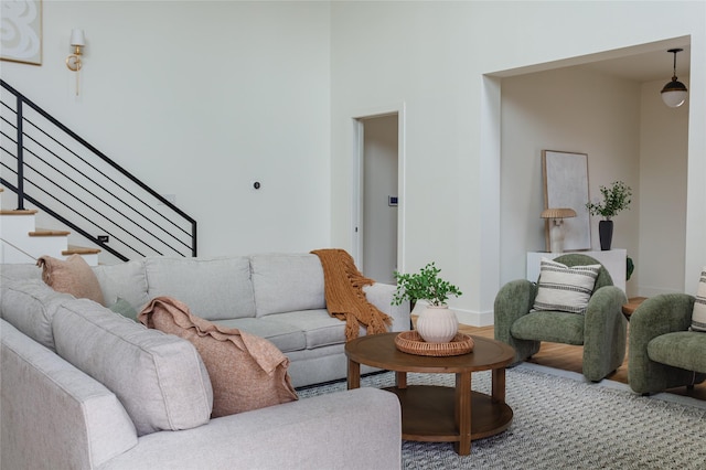 living area featuring stairs, baseboards, and wood finished floors
