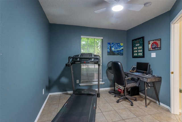 home office with a textured ceiling, ceiling fan, baseboards, and tile patterned flooring