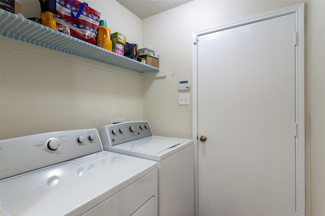 clothes washing area with laundry area, a textured ceiling, and washer and dryer