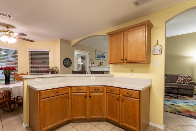 kitchen featuring light tile patterned floors, arched walkways, and visible vents