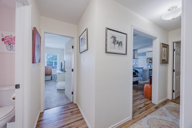 hallway featuring light wood-style floors and baseboards