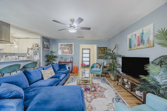 living room featuring light wood finished floors and a ceiling fan