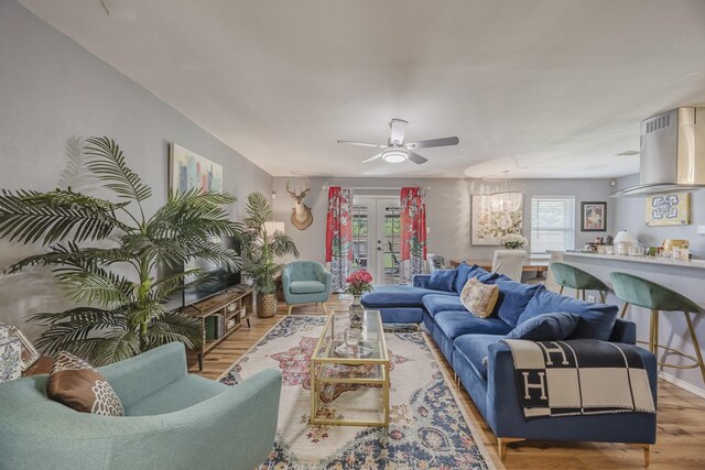 living room with a ceiling fan, wood finished floors, and french doors
