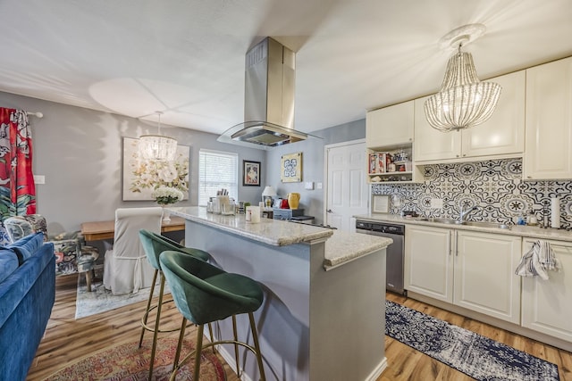 kitchen featuring a chandelier, dishwasher, a sink, and island range hood