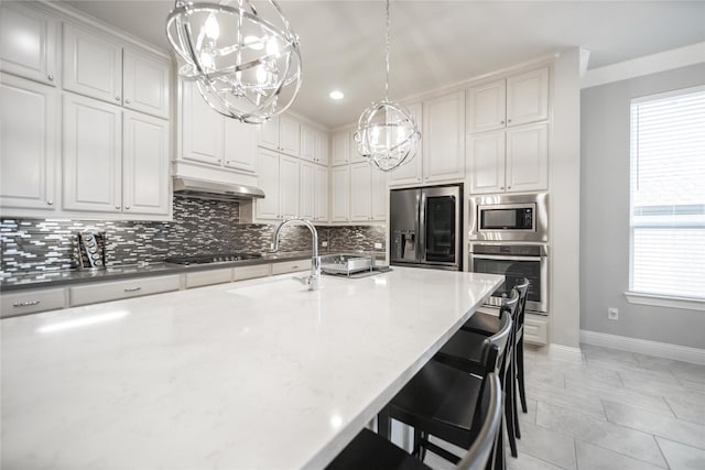 7005 Homestead Dr, Mckinney, TX 75070 - kitchen with appliances with stainless steel finishes, a sink, baseboards, a chandelier, and under cabinet range hood