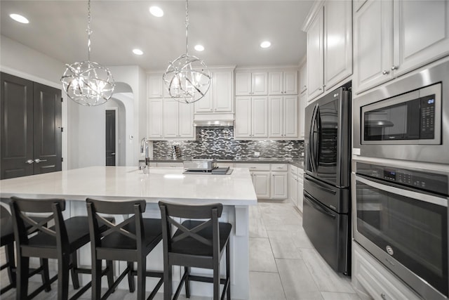7005 Homestead Dr, Mckinney, TX 75070 - kitchen with decorative backsplash, white cabinets, appliances with stainless steel finishes, and a notable chandelier