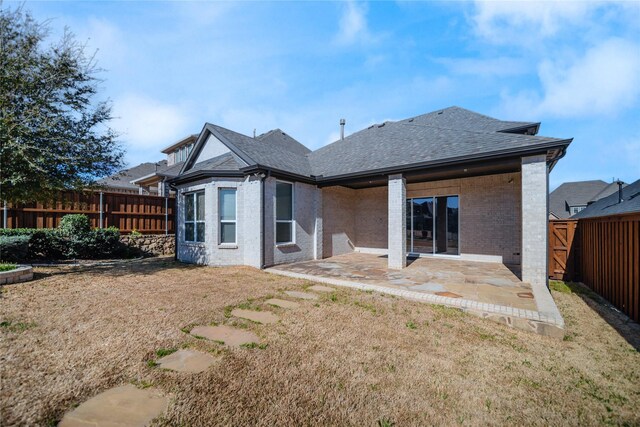 7005 Homestead Dr, Mckinney, TX 75070 - back of property with a patio, a fenced backyard, roof with shingles, brick siding, and a lawn