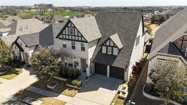 7005 Homestead Dr, Mckinney, TX 75070 - english style home featuring roof with shingles, stucco siding, concrete driveway, an attached garage, and a residential view