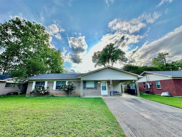 ranch-style house with an attached carport, a front yard, and concrete driveway