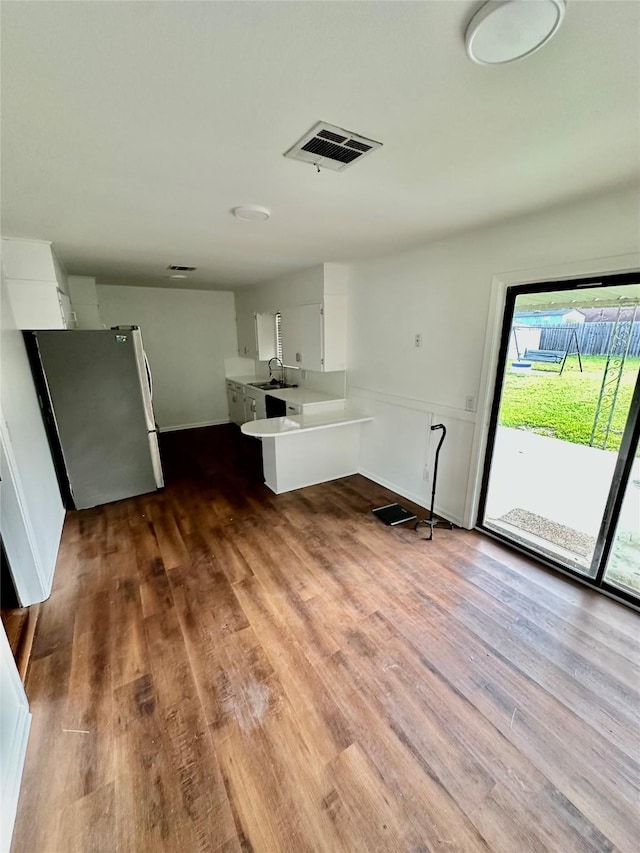 interior space featuring baseboards, visible vents, a sink, and wood finished floors