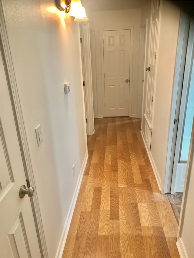 hallway with baseboards and light wood-type flooring