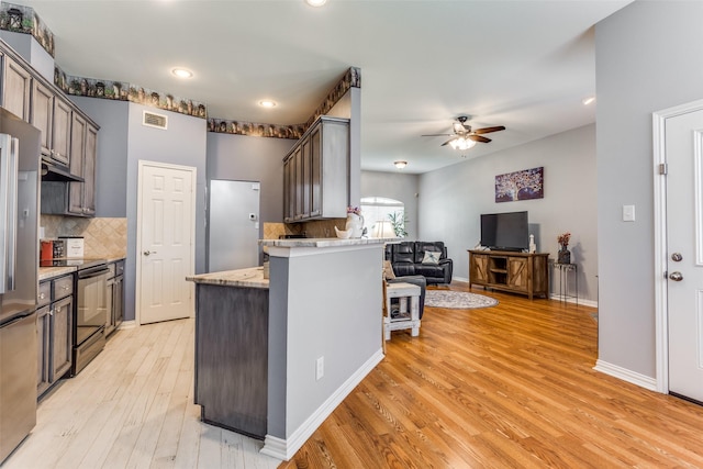 kitchen featuring ceiling fan, light wood-style floors, under cabinet range hood, visible vents, and black range with electric stovetop