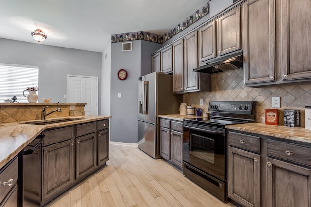 kitchen featuring visible vents, decorative backsplash, under cabinet range hood, a sink, and appliances with stainless steel finishes