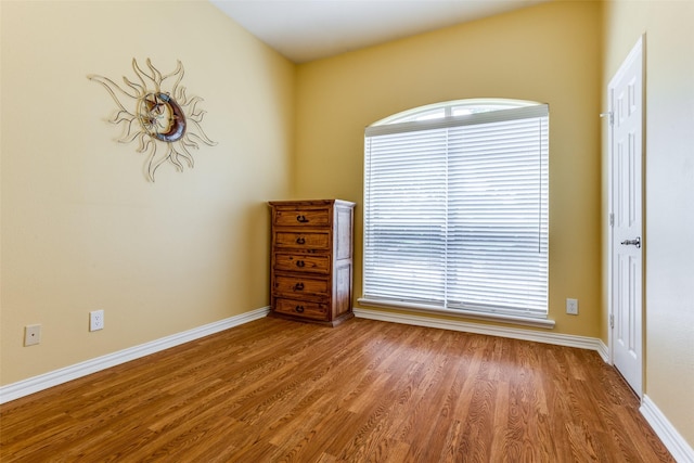 unfurnished room featuring baseboards and wood finished floors