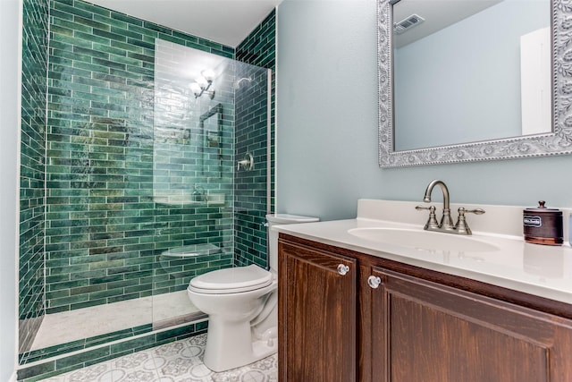 bathroom featuring vanity, toilet, tiled shower, and visible vents
