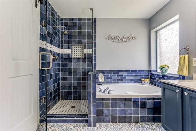 full bath featuring vanity, a shower stall, and a garden tub