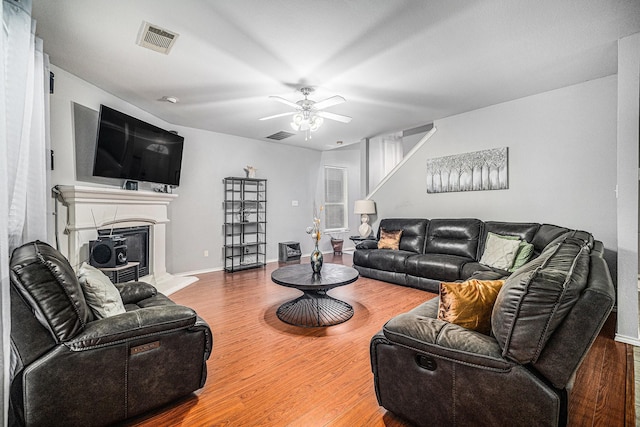 2100 Leandra Ln, Fort Worth, TX 76131 - living room with visible vents, a ceiling fan, a fireplace with raised hearth, and wood finished floors
