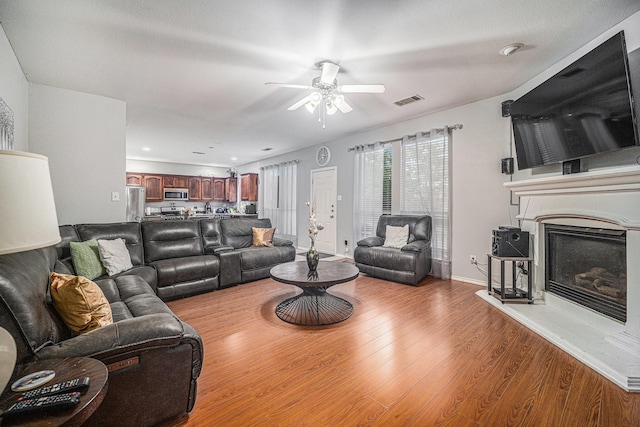 2100 Leandra Ln, Fort Worth, TX 76131 - living room with visible vents, a glass covered fireplace, wood finished floors, baseboards, and ceiling fan