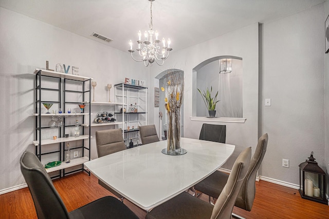 2100 Leandra Ln, Fort Worth, TX 76131 - dining space with a notable chandelier, arched walkways, baseboards, wood finished floors, and visible vents