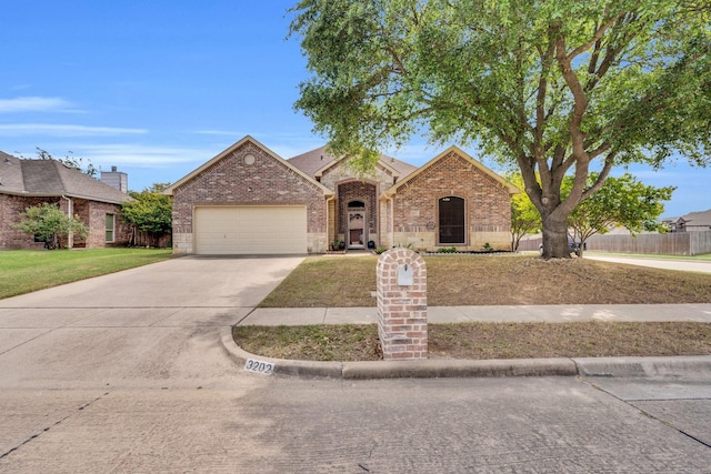 french country inspired facade with fence, a front yard, brick siding, an attached garage, and driveway