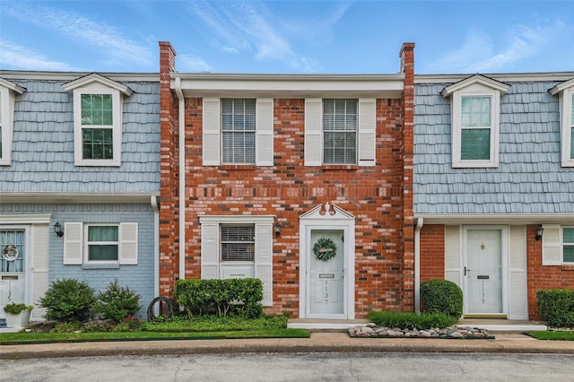 townhome / multi-family property with mansard roof and brick siding