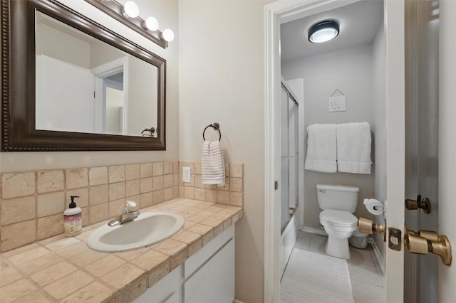 bathroom with tile patterned flooring, vanity, bathtub / shower combination, toilet, and tasteful backsplash