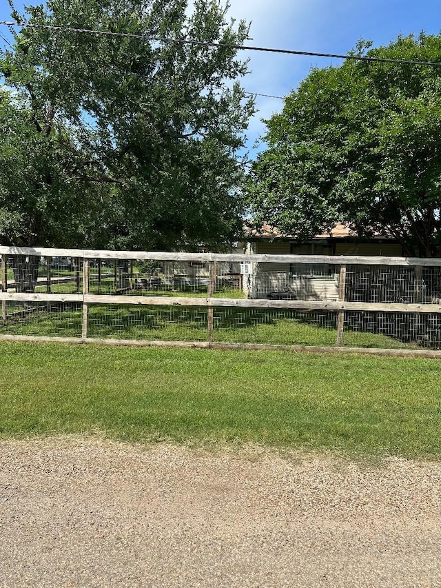 view of property's community featuring a lawn and fence