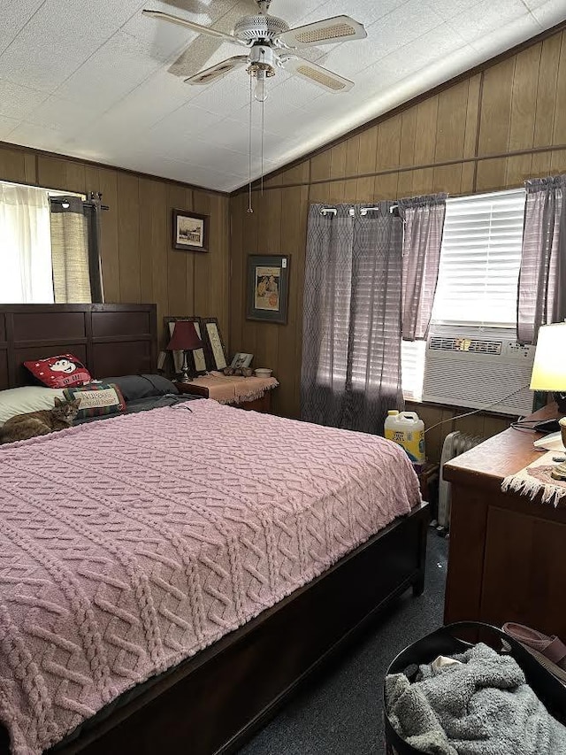 bedroom featuring carpet floors, a ceiling fan, wood walls, and lofted ceiling