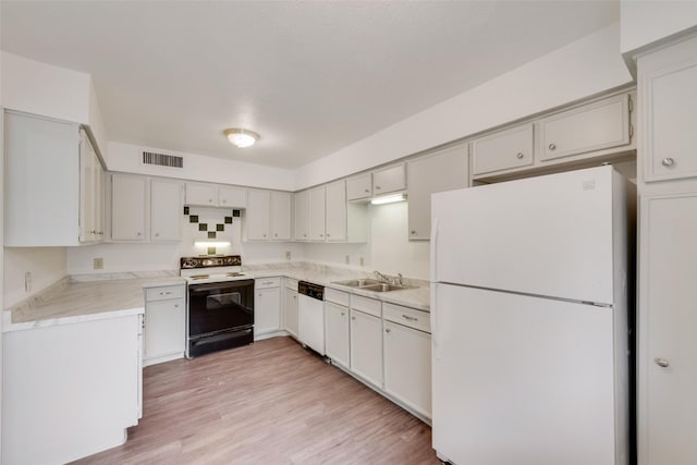 kitchen featuring a sink, light countertops, white appliances, and visible vents