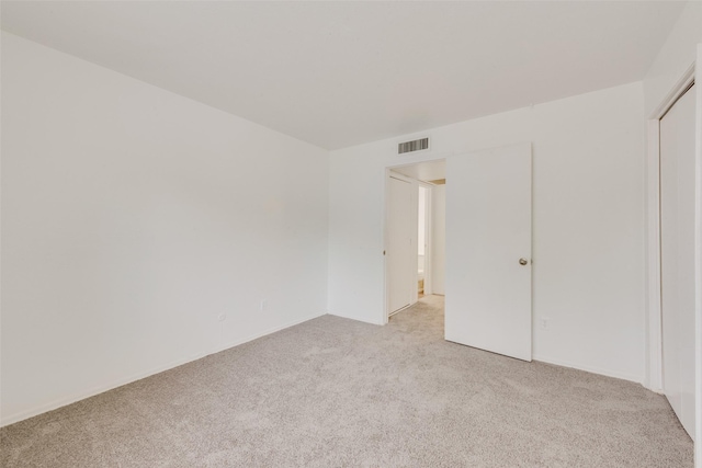 unfurnished bedroom featuring baseboards, light carpet, and visible vents