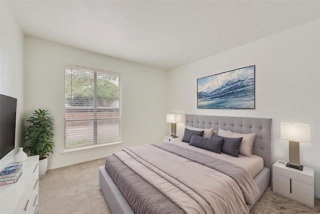 bedroom with baseboards and light carpet