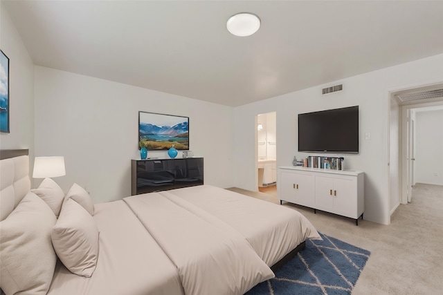 bedroom featuring light colored carpet, ensuite bathroom, and visible vents