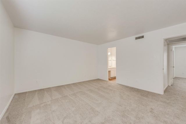 unfurnished room with visible vents, baseboards, and light colored carpet