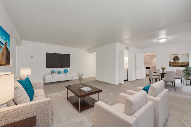 living area with light carpet and visible vents