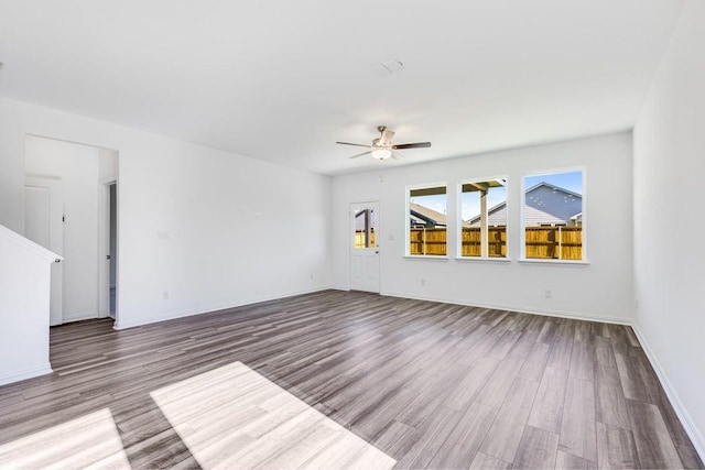 unfurnished living room with baseboards, a ceiling fan, and wood finished floors