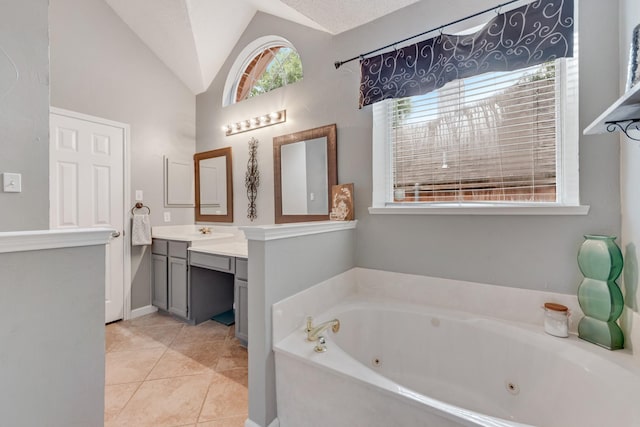 bathroom with vanity, tile patterned floors, lofted ceiling, and a jetted tub
